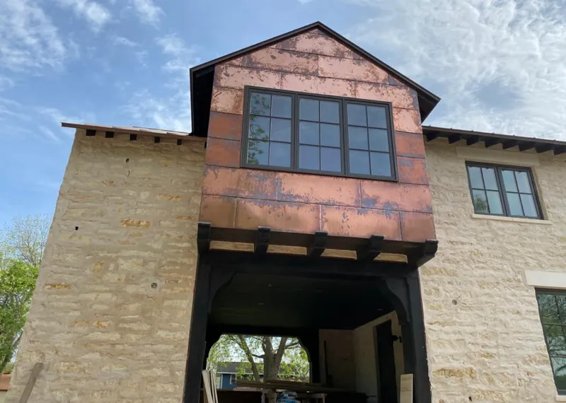 Copper metal panel facade on a stone building for Roof Repair in Farmington